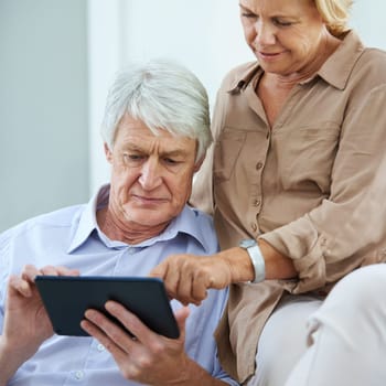 See, its all controlled by a touch. a happy elderly couple using a digital tablet together at home