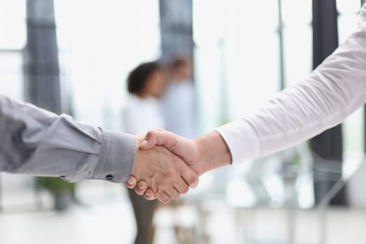 Close up people shaking hands on blurred background