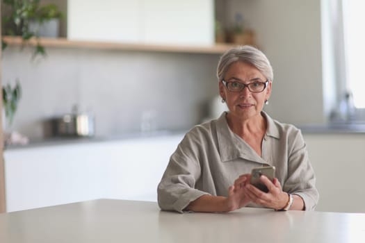 mature woman calls on the phone in the office sitting at the table