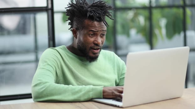 Close-up of a laughing african american man looking into a laptop
