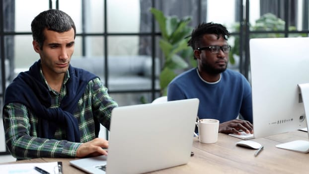 Managers with laptop sitting in modern office