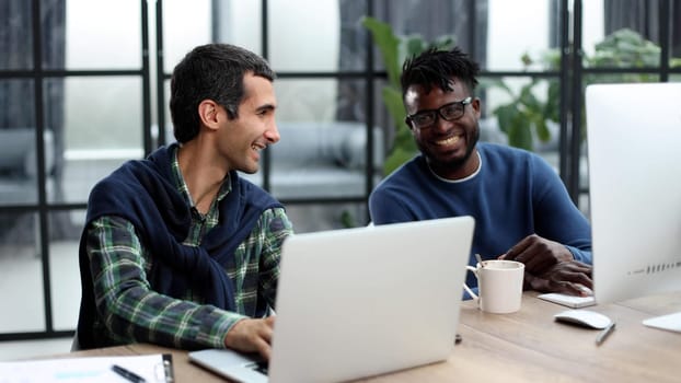 Smiling beautiful businesspeople working on laptop in modern office lobby