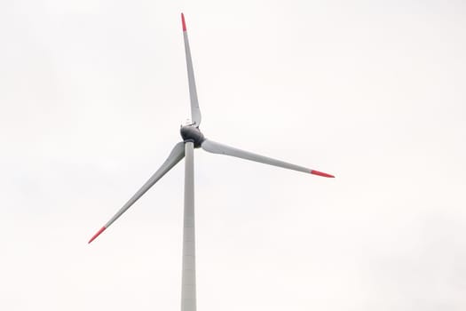 Windmill propeller against the grey sky. Generation of green energy.