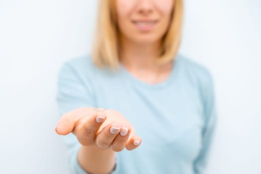 Smiling woman holding contact eye lenses on the tip of the finger