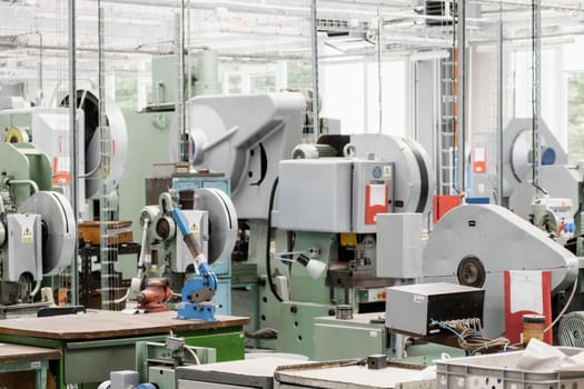 Different contemporary automated machine tools installed to process material and produce goods in light workshop of production plant