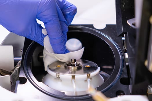 Cleaning of ion source of mass spectrometer by laboratory worker in rubber gloves. LC MS, liquid chromatography and daily routine.