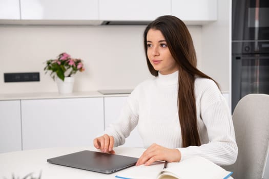 Smart pretty young woman closes a laptop after a lecture online at home.