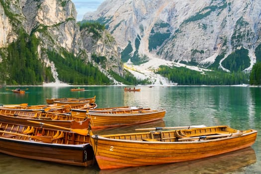 The magnificent Lake Braies with the chain of wooden boats in Dolomites Alps, Italy.