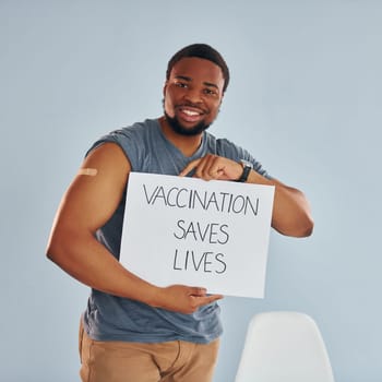 Vaccination saves lives banner. Young african american man after vaccine injection.