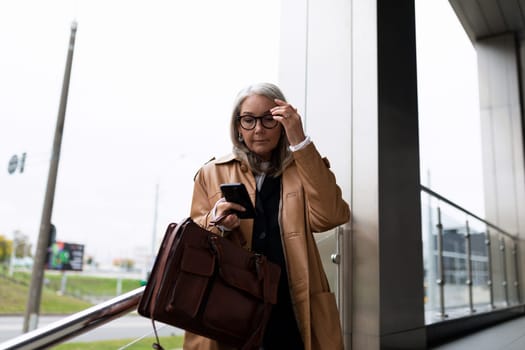 A business woman with a briefcase and a phone in her hands is in a hurry to meet.