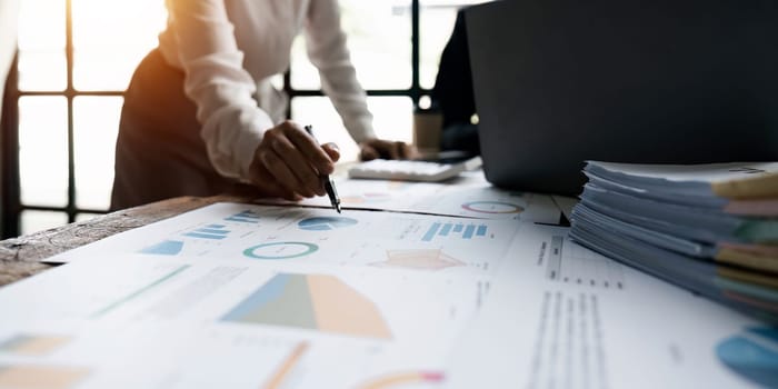 Accountant using a calculator to calculate numbers on a company's financial documents, analyzing historical financial data to plan how to grow the company. Financial concept.