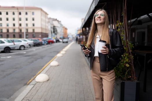 young business woman on the phone in her hands and a cup of coffee.