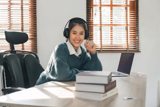 Portrait young asian woman using laptop for online learning at home.