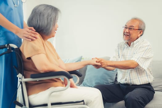 A contented senior couple and their in-home nurse. Elderly female in wheelchair with her young caregiver.