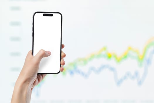 Phone in hand against the background of investment chart, investment concept, broker services, real estate value, economic growth, dividend payout, copy space.