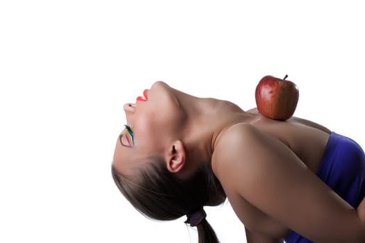 Portrait of flexible young girl posing with apple, close-up