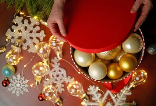 Christmas background with gift box open by woman hands, Preparation for holidays. View from above.