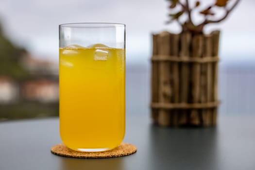 A bright yellow glass filled with freshly squeezed Passion fruit juice, providing a refreshing drink for the household.