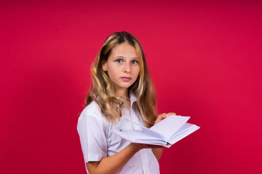 Child making notes. Kids dreams.Isolated on a red background. Education, Kid back to school.