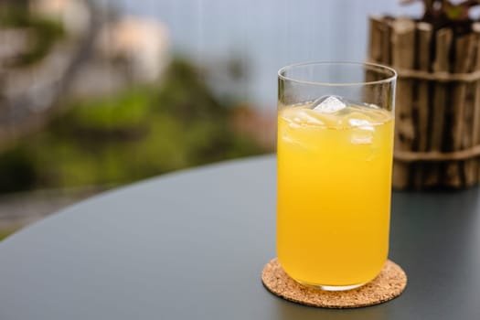 A bright yellow glass filled with freshly squeezed Passion fruit juice, providing a refreshing drink for the household.