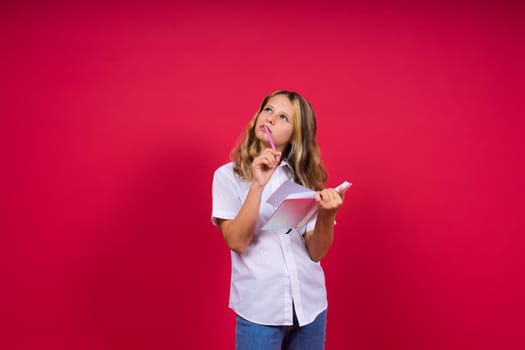 Child making notes. Kids dreams.Isolated on a red background. Education, Kid back to school.