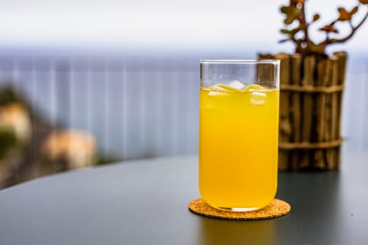 A bright yellow glass filled with freshly squeezed Passion fruit juice, providing a refreshing drink for the household.