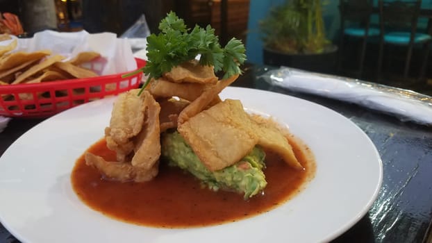 Fish chicharron with red sauce and guacamole. Mexican gourmet seafood served with fresh corn tortillas.