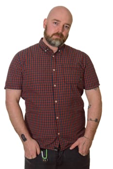 Tattooed skinhead with beard in checked shirt on white background. Subculture editorial photo