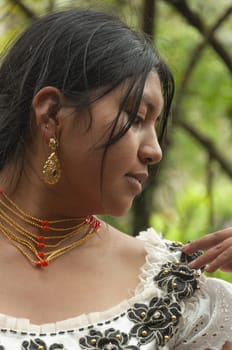 the indigenous girl is showing her earrings and walkas and necklaces