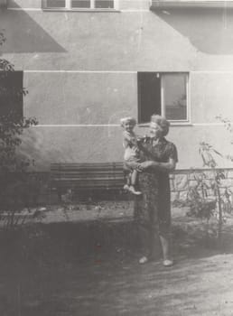 THE CZECHOSLOVAK SOCIALIST REPUBLIC - CIRCA 1950s: Vintage photo shows grandmother holds a small baby. Retro black and white photography. Circa 1950.