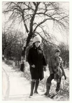 THE CZECHOSLOVAK SOCIALIST REPUBLIC - 1976: Vintage photo shows mother and daughter in the winter time. Retro black and white photography. Circa 1980.