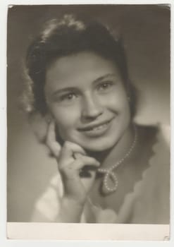 THE CZECHOSLOVAK SOCIALIST REPUBLIC - 1960: Vintage photo shows a teenager girl poses in the photography studio. Photo with blurred tint. Retro black and white photography. Circa 1960.