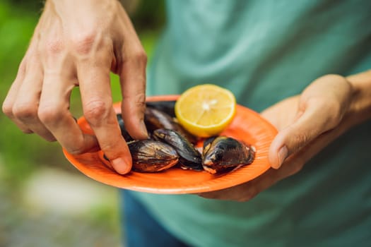 Heap of mussels in shells stuffed with rice. Man is going to eat midye traditional Turkish food. Istanbul, Turkey.