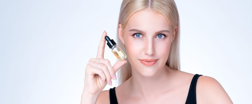 Personable portrait of beautiful woman applying extracted cannabis oil bottle for skincare product. CBD oil dropper pipette for cosmetology treatment and cannabinoids concept in isolated background.