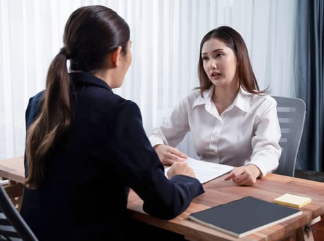 Business deal meeting, young businesswomen carefully reviewing terms and condition of contract agreement papers in office. Corporate lawyer give consultation on contract deal. Enthusiastic