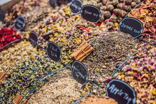 Market counter with different types of tea, herbs, plants, and dried flowers.