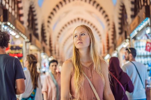 A tourist woman walks among the countless shops at the Grand Bazaar and Egyptian Bazaar in Istanbul. Shopping and travel in Turkey concept. Istanbul historical Egyptian Bazaar. Misir Carsisi, spice market. Turkiye.