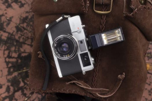 analog photo camera with flash on a brown backpack. High quality photo