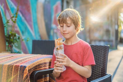 Boy eating street food in Istanbul. Balik ekmek - fish in a bread, traditional Turkish fast food. Istanbul, Turkey.