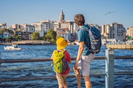 Father and son tourists enjoy Istanbul city skyline in Turkey, Beyoglu district old houses with Galata tower on top, view from the Golden Horn.