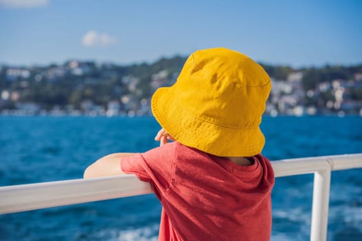 Happy boy enjoying the sea from ferry boat crossing Bosphorus in Istanbul. Summer trip to Istanbul. Traveling with kids concept.