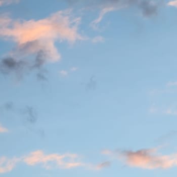 Background of blue sky with pale pink clouds at sunset