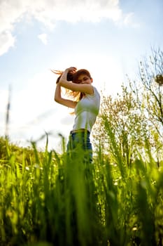 joyful woman posing in tall grass on a sunny day. High quality photo