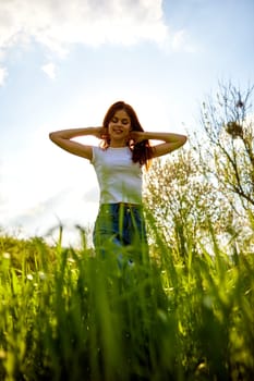 bright, happy woman posing while standing in tall grass. High quality photo