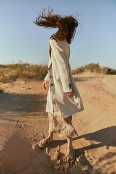 a woman in stylish, summer clothes stands in poses posing with her face covered by her hair. High quality photo