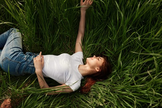 happy peaceful woman lies in the park on high grass. High quality photo