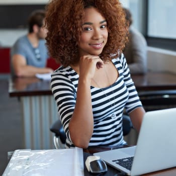 My work makes me happy. a young businesswoman using wireless technology in an office