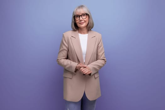 confident 60s middle aged woman in stylish look smiling against bright studio background.