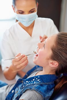 Your teeth are looking great. a female dentist and child in a dentist office