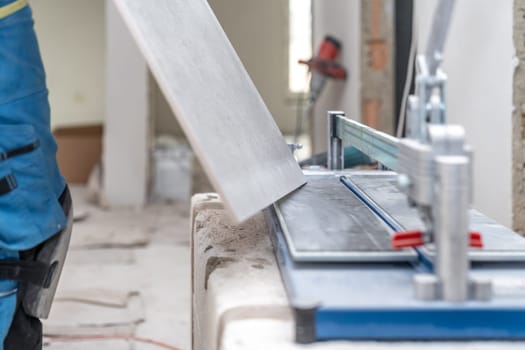 manual cutting of facing tiles on a cutter. High quality photo